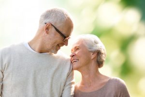 happy senior couple over green natural background family, age, love, relations and people concept - happy senior couple over green natural background