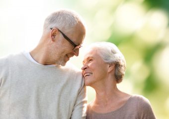 family, age, love, relations and people concept - happy senior couple over green natural background